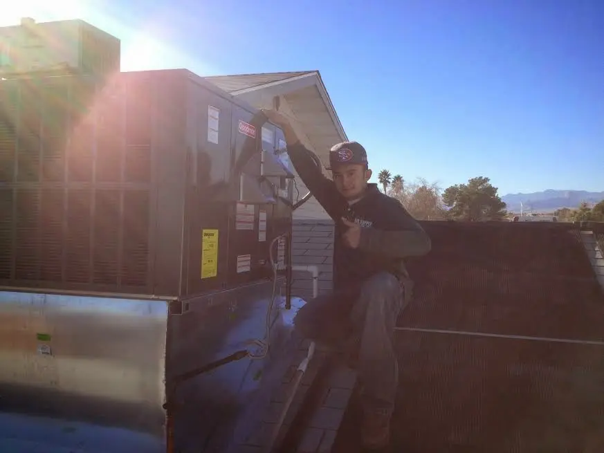 HVAC technician performing AC Tune-Up on a rooftop unit in Sherwood